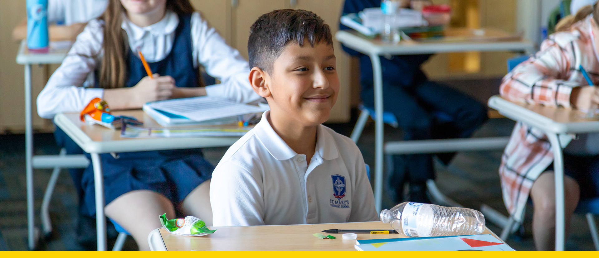 Little boy in a classroom sitting at a desk